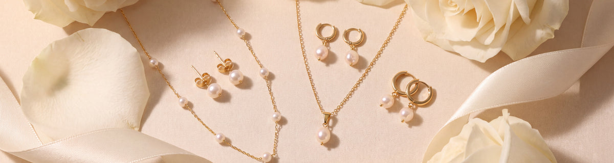 Freshwater pearl necklaces and earrings among white rose petals and satin ribbon