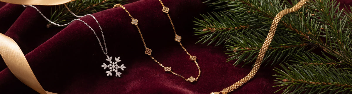 Snowflake, clover and chain jewelry on burgundy velvet with pine and red berries