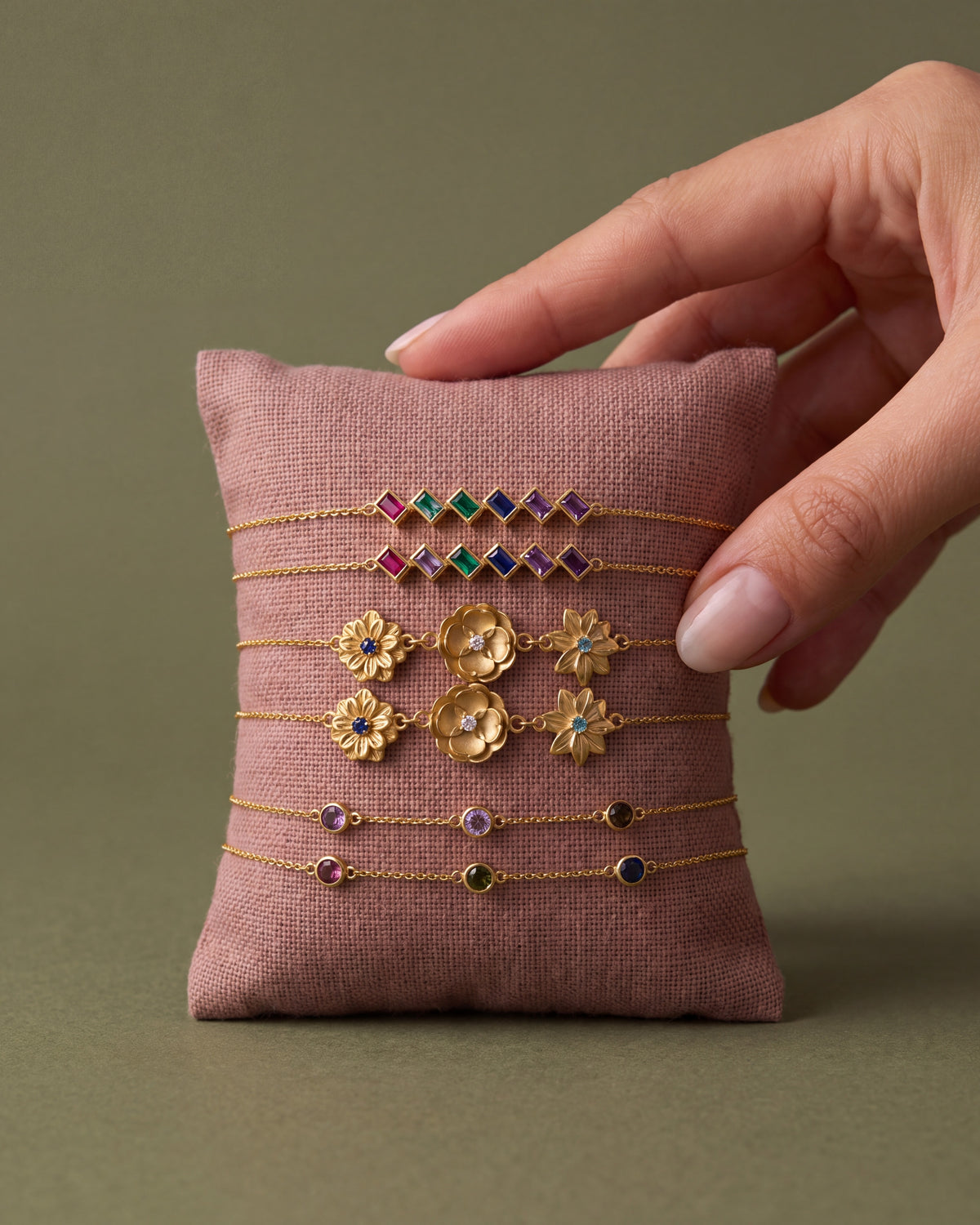 Best-selling gold birthstone bracelets on a linen cushion