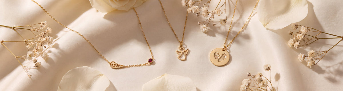 Dainty gold angel and memorial necklaces on ivory silk with baby's breath