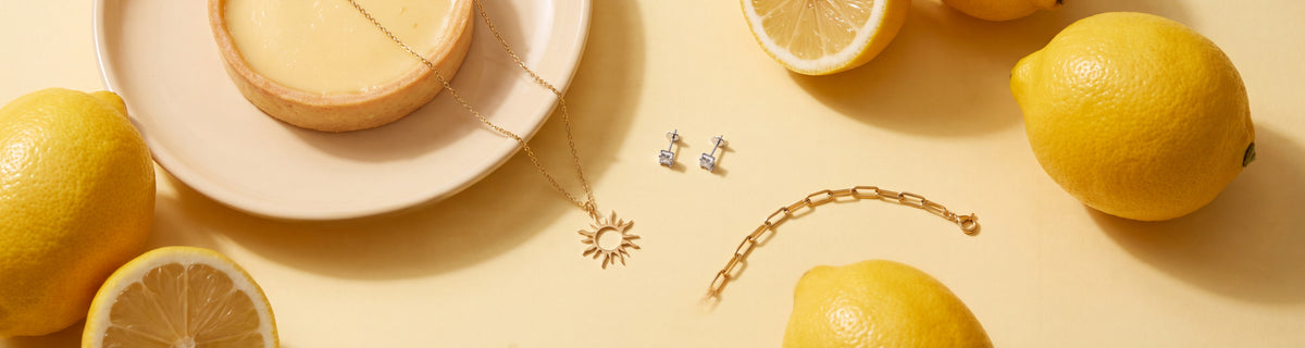 Dainty gold jewelry under $50 with fresh lemons and a lemon tart
