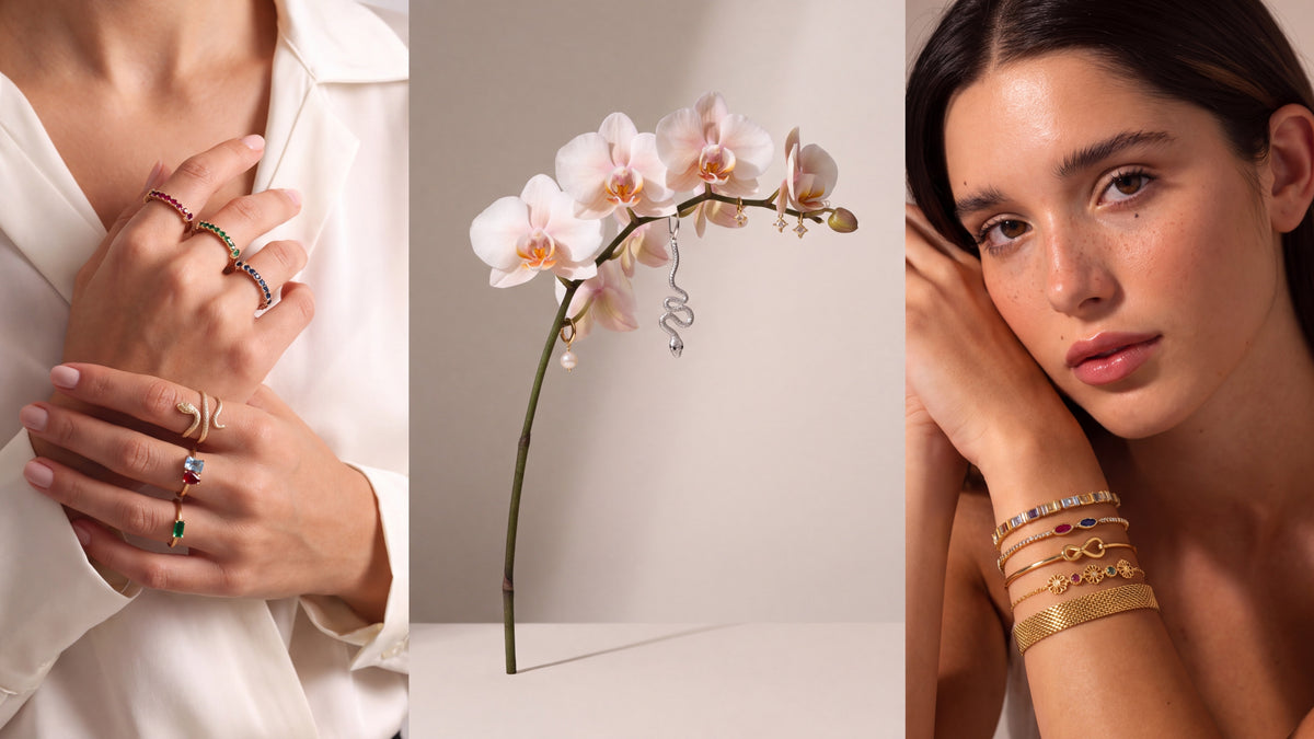 Gold birthstone rings, pearl and snake earrings on an orchid stem, and a stack of dainty gold bracelets